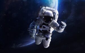 An astronaut on a spacewalk with Earth in the background. Innovation in manufacturing with the help of companies like PQ Ovens will help make space more accessible.