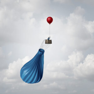deflated-hot-air-balloon-with-basket-and-passenger-held-in-air-by-smaller-balloon